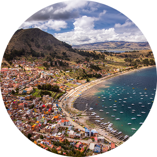 Una vista aérea de una ciudad costera ecuatoriana con casas coloridas y barcos en el mar.