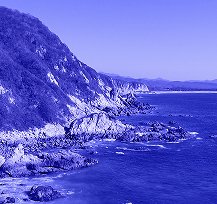 Una costa rocosa con un horizonte vasto y un cielo azul claro, reflejando la serenidad y la calma de un día perfecto para enviar envíos internacionales desde Ecuador.