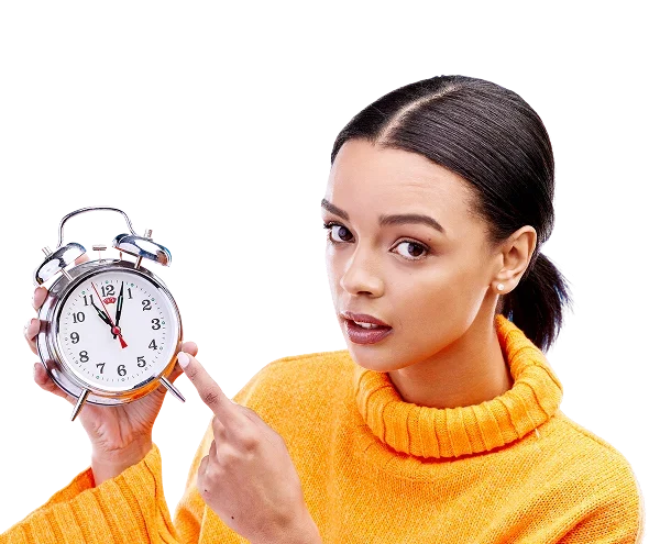 Una mujer con un reloj en la mano, apuntando a la hora, en un fondo negro.