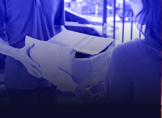 Persona recibiendo o enviando un paquete en una caja de cartón grande abierta.