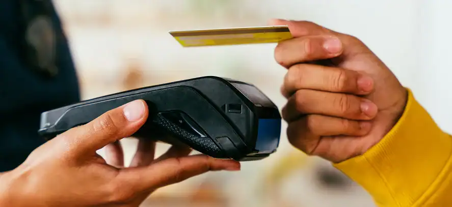 Persona sosteniendo tarjetas de crédito y de identificación.