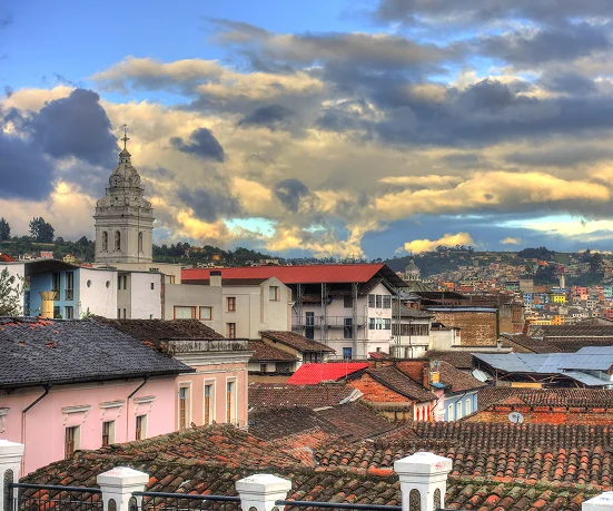 Una ciudad pintoresca bajo un cielo dramático, con edificios coloridos y un paisaje hilly