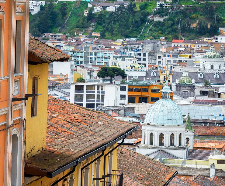 Vista panorámica de una ciudad con arquitectura única y colores vibrantes, ubicada en un paisaje natural.